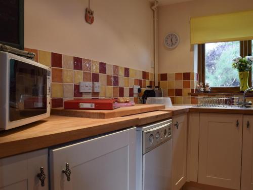 a kitchen with a microwave and a stove top oven at The Cider Press in Welland