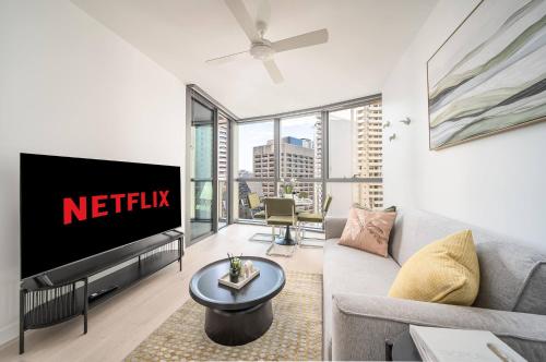 a living room with a tv and a couch at Skyscraper Cinema - Dream a thousand city lights in Brisbane