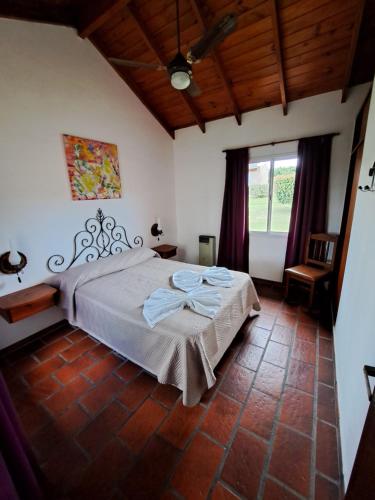 a bedroom with a bed and a large window at Vista Bella Cabañas in La Falda