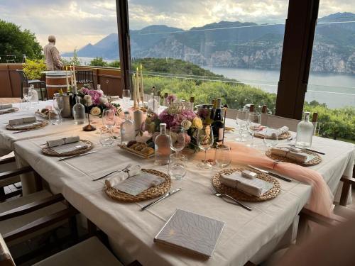 a dining table with a view of the water and mountains at Hotel Querceto Wellness & Spa - Garda Lake Collection in Malcesine