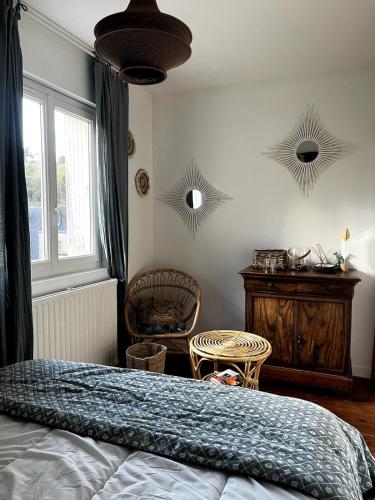 a bedroom with a bed and a table and two mirrors at Fécamp Beachfront House in Fécamp