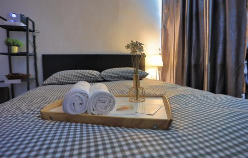 a tray with towels and a vase with flowers on a bed at SS15 Courtyard Subang Jaya Sunway Home Cinema Projector Studio 120 Inches in Subang Jaya