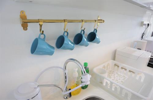 a kitchen sink with blue mugs hanging from a rack at SS15 Courtyard Subang Jaya Sunway Home Cinema Projector Studio 120 Inches in Subang Jaya