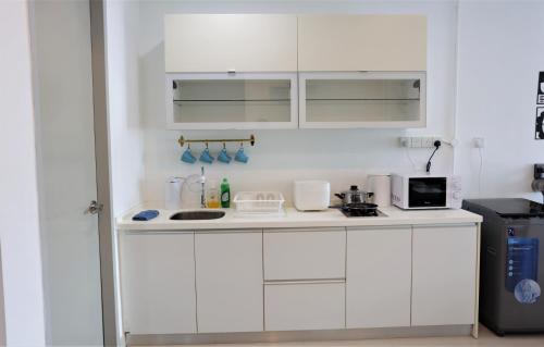 a white kitchen with a sink and a microwave at SS15 Courtyard Subang Jaya Sunway Home Cinema Projector Studio 120 Inches in Subang Jaya