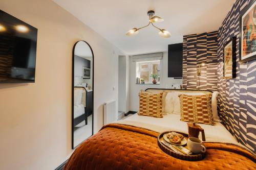a bedroom with a large bed and a mirror at Hotwells I Your Apartment in Bristol