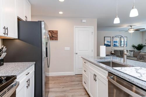 a kitchen with white cabinets and a stainless steel refrigerator at Rustic Chic Mountain Home 15 min from DT Asheville in Fletcher
