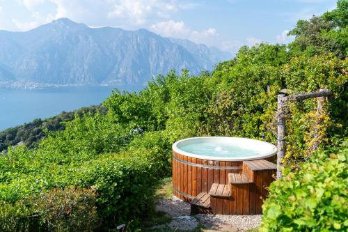 a hot tub on a hill with a view of the mountains at Hotel Querceto Wellness & Spa - Garda Lake Collection in Malcesine