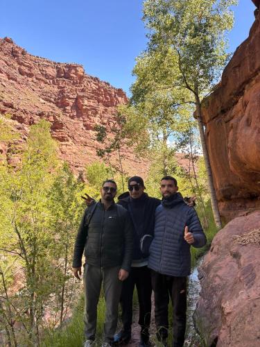 a group of three men standing in front of a canyon at Gite Megdaz in Megdaz