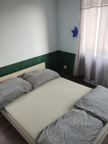 a bed in a bedroom next to a window at Pepe Apartment 40 mkw in Szczecin