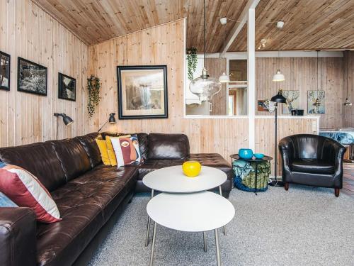 a living room with a leather couch and a table at 8 person holiday home in Ebeltoft in Ebeltoft