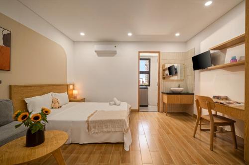 ein Hotelzimmer mit einem Bett und einem Tisch mit Blumen in der Unterkunft Carol Homestay & Apartment 5 in Đà Nẵng