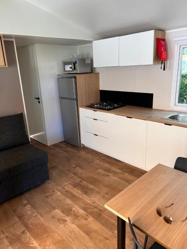a kitchen with a couch and a table in a room at le plein de bonheur in Fréjus
