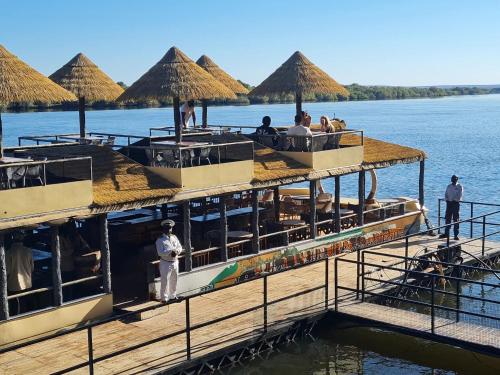 a boat on the water with people on the deck at Mukuni Villas in Livingstone