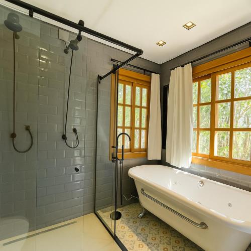a bathroom with a bath tub and a shower at Pousada Flores do Cerrado in Pirenópolis