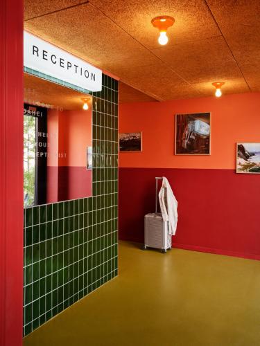 a room with a red and green wall with a suitcase at Dahei Apartment Hotel in Copenhagen