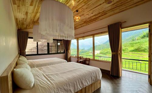 a bedroom with two beds and a large window at S Plus Bungalow in Sa Pa