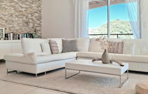 un salon blanc avec un canapé blanc et une table dans l'établissement Awesome Home In St Nazaire De Ladarez, à Saint-Nazaire-de-Ladarez