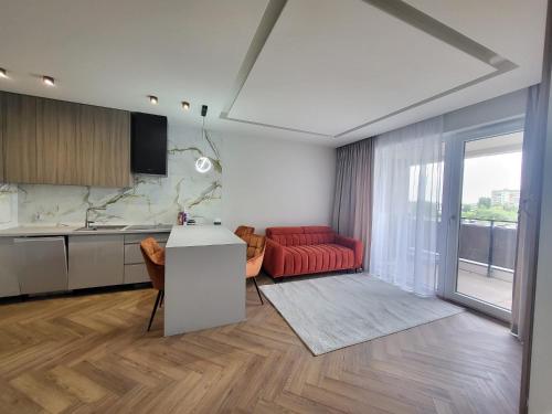 a kitchen and a living room with a red couch at Apartaments by Ola in Radom