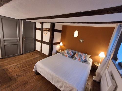 a bedroom with a white bed and two lamps at Gite le 1788 in Scherwiller