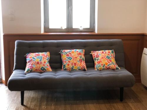 a couch with four pillows on it in a room at Gite le 1788 in Scherwiller