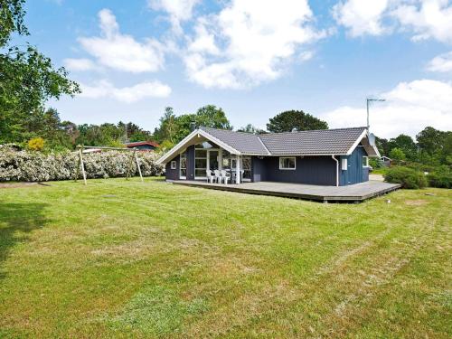 uma pequena casa azul com um grande quintal em 7 person holiday home in Asnæs-By Traum em Asnæs