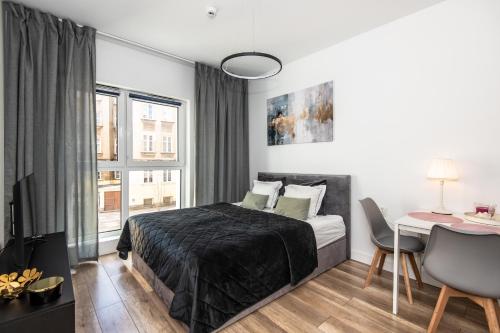 a bedroom with a bed and a table and a desk at Super-Apartamenty Plac Wolności 6 in Poznań
