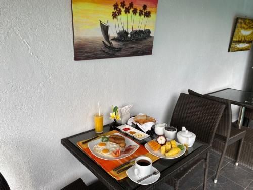 una mesa de desayuno con alimentos y café. en D Villas, en Sri Jayewardenepura Kotte