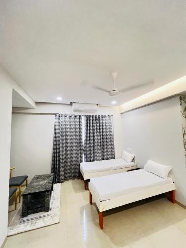 a hospital room with two beds and a fireplace at Hotel Sai Agastya Inn in Shirdi