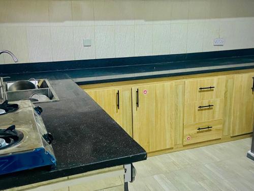 a kitchen with wooden cabinets and a black counter top at 3 Bedroom in Lekki Lagos in Lekki