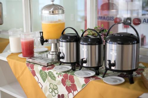 a table topped with a counter with two coffee makers at Hotel Casa Enseada Guarujá in Guarujá