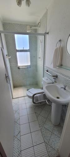 a bathroom with a sink and a toilet and a shower at Hotel Casa Enseada Guarujá in Guarujá