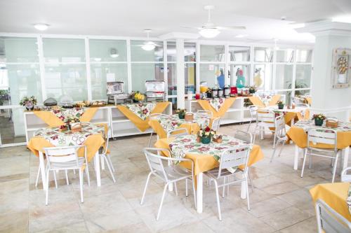 a restaurant with tables and chairs and a counter at Hotel Casa Enseada Guarujá in Guarujá