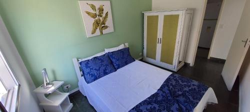 a bedroom with a blue and white bed and a window at Hotel Casa Enseada Guarujá in Guarujá