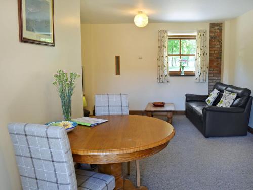 a living room with a wooden table and chairs at Shire Cottage in Sewerby