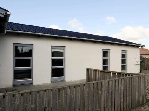 a white house with a wooden fence at 6 person holiday home in Lemvig-By Traum in Ferring
