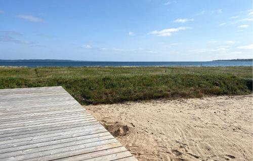 a wooden boardwalk on a beach near the ocean at 4 Bedroom Amazing Home In Fredericia in Fredericia