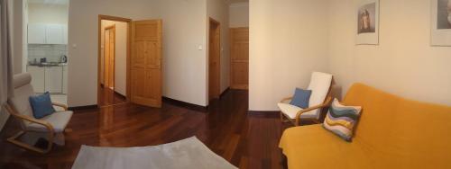 a living room with a yellow couch and chairs at Mooi Panzió in Nagyatád