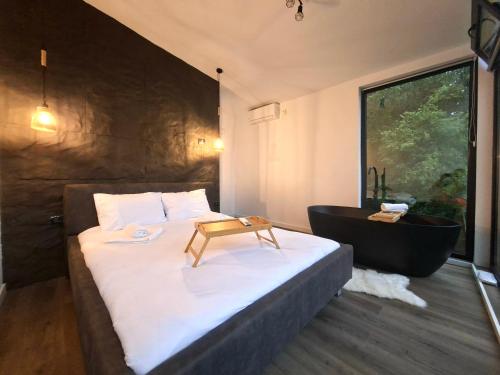 a bedroom with a large bed and a bath tub at Panoramic Box in Vişeu de Sus