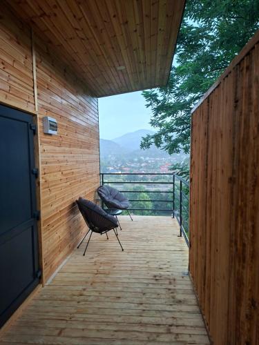 a wooden patio with a view of the mountains at Panoramic Box in Vişeu de Sus