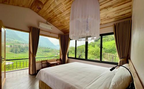 a bedroom with a bed and a large window at S Plus Bungalow in Sa Pa
