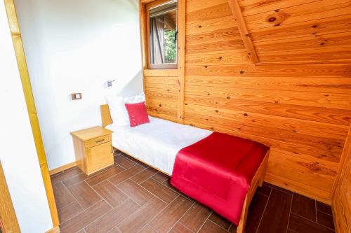 a small bedroom with wood paneling and a red seat at Etno Naselje Vrdnička kula in Vrdnik