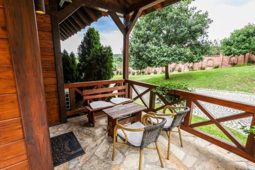 a wooden porch with a table and chairs on it at Etno Naselje Vrdnička kula in Vrdnik