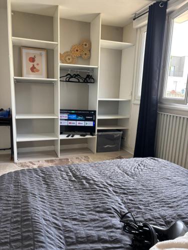 a bedroom with a bed and shelves and a window at Urban Stay Rennes - Logement entier à Saint-Jacques de la Lande in Saint-Jacques-de-la-Lande