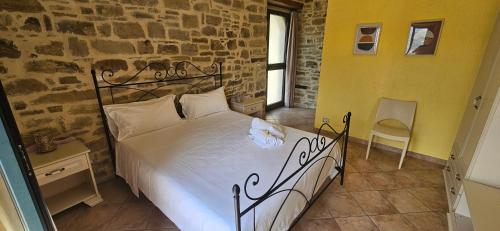 a bedroom with a bed and a stone wall at PASCHIERE by Keyhole Selection in Castelmezzano