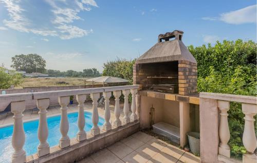 an outdoor grill on a balcony next to a swimming pool at Gorgeous Home In Cessenon Sur Orb in Cessenon