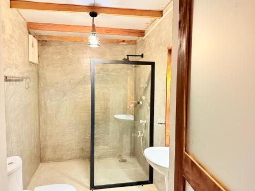 a bathroom with a shower and a toilet and a sink at Elephant Gate Arugambay in Arugam Bay
