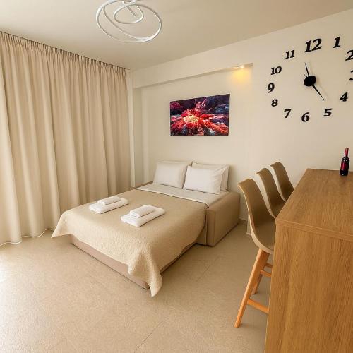 a bedroom with two beds and a clock on the wall at Fortaleza Rooms Pefkochori in Pefkochori