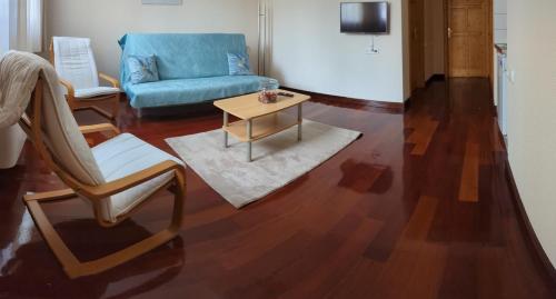 a living room with a couch and a chair and a table at Mooi Panzió in Nagyatád
