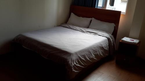 a bedroom with a bed with white sheets and a window at Sport Guest House in Addis Ababa