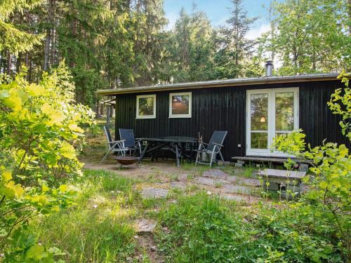 a black cabin with a picnic table and chairs at 4 person holiday home in Bryrup-By Traum in Bryrup